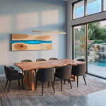 Handcrafted Queensland Maple dining table with glass centrepiece and refectory legs in a dining room overlooking a waterfall flowing into a pool